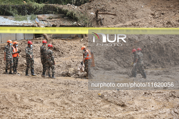 Nepal Army personnel walk through the mud carrying search equipment in Jhyaple Khola of Dhading in Central Nepal, on September 29, 2024, whe...