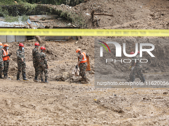 Nepal Army personnel walk through the mud carrying search equipment in Jhyaple Khola of Dhading in Central Nepal, on September 29, 2024, whe...