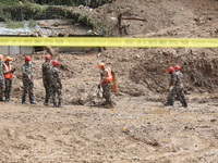 Nepal Army personnel walk through the mud carrying search equipment in Jhyaple Khola of Dhading in Central Nepal, on September 29, 2024, whe...