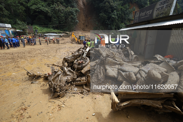 Debris of passenger vehicles excavated by Nepali security personnel while searching for missing passengers lies on the site of a landslide i...