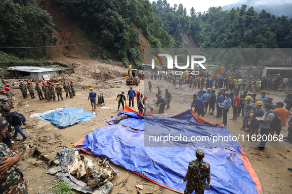 Nepal Army personnel carry the body of a passenger retrieved from the landslide site in Jhyaple Khola in Dhading district of Central Nepal o...