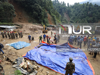 Nepal Army personnel carry the body of a passenger retrieved from the landslide site in Jhyaple Khola in Dhading district of Central Nepal o...