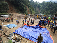 Nepal Army personnel carry the body of a passenger retrieved from the landslide site in Jhyaple Khola in Dhading district of Central Nepal o...