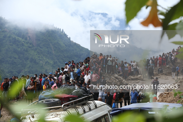 Locals and relatives of the missing passengers gather at Jhyaple Khola in Dhading District, Nepal, on September 29, 2024, as the search oper...