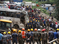 Personnel from Nepal's security agencies, the Nepal Army, Armed Police Force, and the Nepal Police continue a search operation at a landslid...