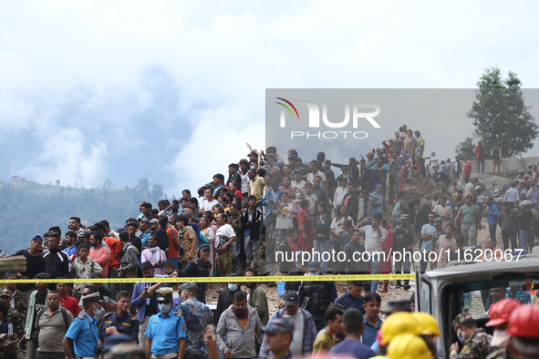 Locals and relatives of the missing passengers gather at Jhyaple Khola in Dhading District, Nepal, on September 29, 2024, as the search oper...