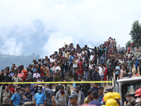 Locals and relatives of the missing passengers gather at Jhyaple Khola in Dhading District, Nepal, on September 29, 2024, as the search oper...