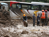 Nepal's Armed Police Force (APF) personnel roll out the remains of a passenger bus from the disaster site in Jhyaple Khola of Dhading Distri...