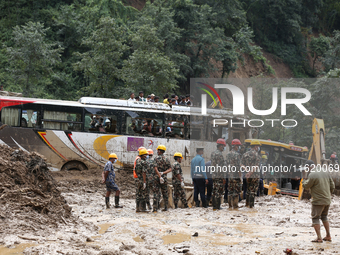 Personnel from Nepal's security agencies, the Nepal Army, Armed Police Force, and the Nepal Police continue a search operation at a landslid...