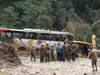 Personnel from Nepal's security agencies, the Nepal Army, Armed Police Force, and the Nepal Police continue a search operation at a landslid...