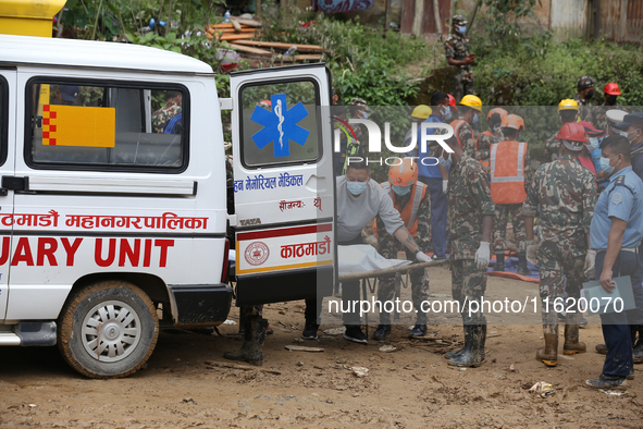 Personnel from Nepal's security agencies, the Nepal Army, Armed Police Force, and the Nepal Police transfer a body into the hearse at a land...