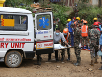 Personnel from Nepal's security agencies, the Nepal Army, Armed Police Force, and the Nepal Police transfer a body into the hearse at a land...