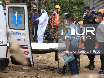 Personnel from Nepal's security agencies, the Nepal Army, Armed Police Force, and the Nepal Police transfer a body into the hearse at a land...