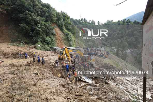 Personnel from Nepal's security agencies, the Nepal Army, Armed Police Force, and the Nepal Police continue a search operation at a landslid...