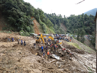 Personnel from Nepal's security agencies, the Nepal Army, Armed Police Force, and the Nepal Police continue a search operation at a landslid...