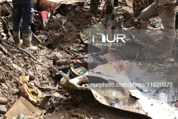 Personnel from Nepal's security agencies, the Nepal Army, Armed Police Force, and the Nepal Police recover a body from a landslide disaster...