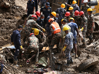 Personnel from Nepal's security agencies, the Nepal Army, Armed Police Force, and the Nepal Police recover a body from a landslide disaster...