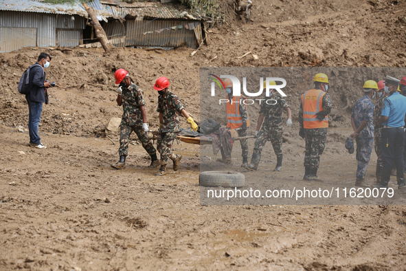 Nepal Army personnel carry the body of a passenger retrieved from the landslide site in Jhyaple Khola in Dhading district of Central Nepal o...