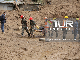 Nepal Army personnel carry the body of a passenger retrieved from the landslide site in Jhyaple Khola in Dhading district of Central Nepal o...