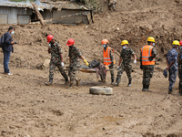 Nepal Army personnel carry the body of a passenger retrieved from the landslide site in Jhyaple Khola in Dhading district of Central Nepal o...