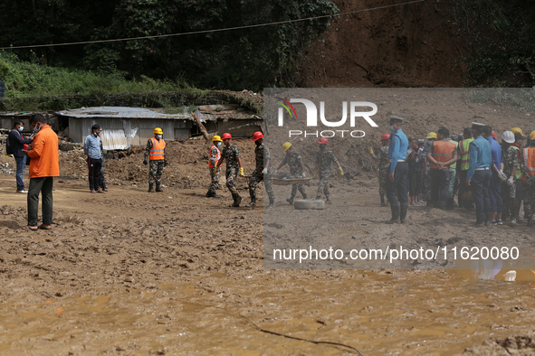 Nepal Army personnel carry the body of a passenger retrieved from the landslide site in Jhyaple Khola in Dhading district of Central Nepal o...