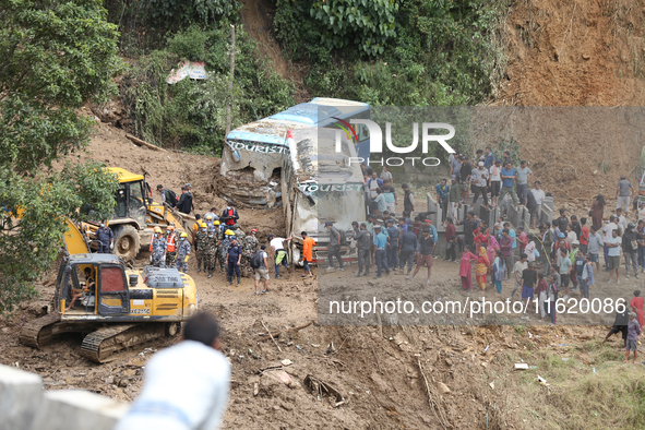 Stranded passengers cross a landslide in Jhyaple Khola in Dhading District of Central Nepal on September 29, 2024. At least 35 people are co...