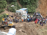 Stranded passengers cross a landslide in Jhyaple Khola in Dhading District of Central Nepal on September 29, 2024. At least 35 people are co...