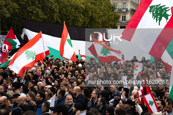 Protesters wave Lebanese flags during a demonstration in support of Lebanese people as intense Israeli attacks across Lebanon's east, south,...