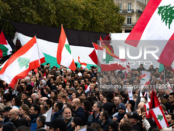 Protesters wave Lebanese flags during a demonstration in support of Lebanese people as intense Israeli attacks across Lebanon's east, south,...