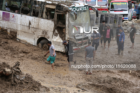 Stranded passengers cross a landslide in Jhyaple Khola in Dhading District of Central Nepal on September 29, 2024. At least 35 people are co...