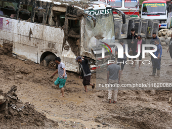 Stranded passengers cross a landslide in Jhyaple Khola in Dhading District of Central Nepal on September 29, 2024. At least 35 people are co...