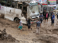 Stranded passengers cross a landslide in Jhyaple Khola in Dhading District of Central Nepal on September 29, 2024. At least 35 people are co...