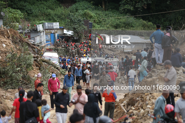 Stranded passengers cross a landslide in Jhyaple Khola in Dhading District of Central Nepal on September 29, 2024. At least 35 people are co...