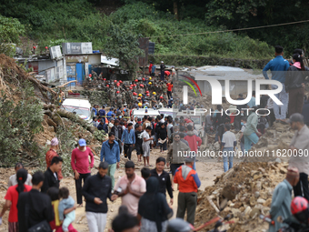 Stranded passengers cross a landslide in Jhyaple Khola in Dhading District of Central Nepal on September 29, 2024. At least 35 people are co...