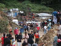 Stranded passengers cross a landslide in Jhyaple Khola in Dhading District of Central Nepal on September 29, 2024. At least 35 people are co...