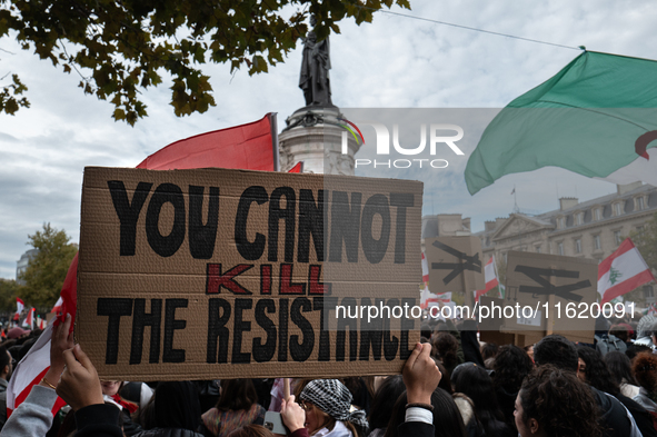 A protester holds a sign reading "you cannot kill the resistance" during a demonstration in support of Lebanese people as intense Israeli at...