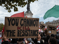 A protester holds a sign reading "you cannot kill the resistance" during a demonstration in support of Lebanese people as intense Israeli at...