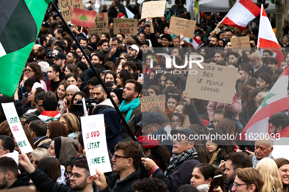 A protester holds a sign reading "stop killing the Lebanese people" during a demonstration in support of Lebanese people as intense Israeli...