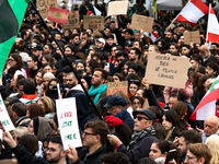 A protester holds a sign reading "stop killing the Lebanese people" during a demonstration in support of Lebanese people as intense Israeli...