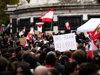 A protester holds a sign reading "Hands off Lebanon" during a demonstration in support of Lebanese people as intense Israeli attacks across...