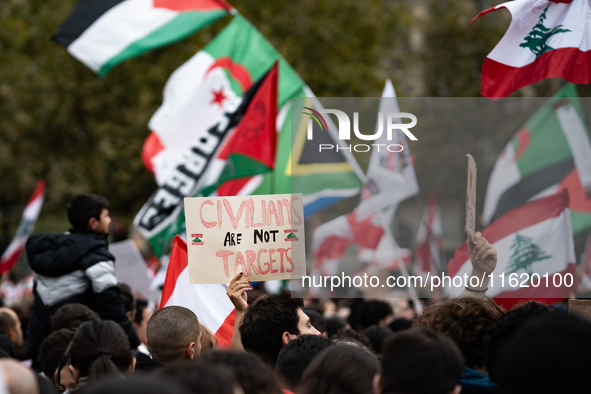 A protester holds a sign reading "civilians are not targets" during a demonstration in support of Lebanese people as intense Israeli attacks...