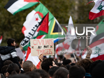 A protester holds a sign reading "civilians are not targets" during a demonstration in support of Lebanese people as intense Israeli attacks...