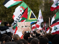 A protester holds a sign reading "civilians are not targets" during a demonstration in support of Lebanese people as intense Israeli attacks...