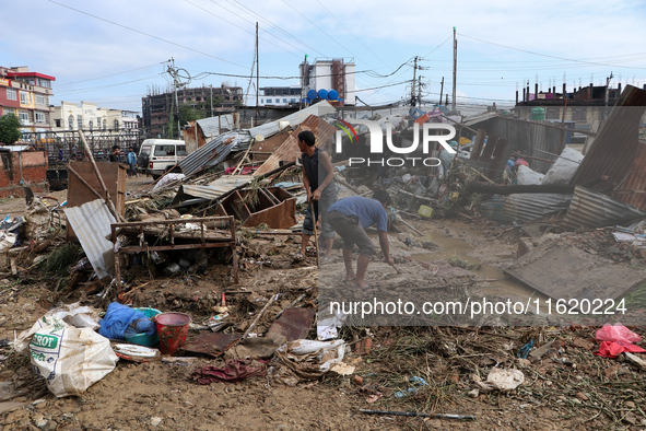 People in Imadol, Lalitpur, Nepal, salvage their damaged properties after heavy rain triggers waterlogging in the area on September 29, 2024...