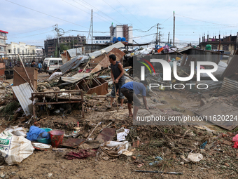 People in Imadol, Lalitpur, Nepal, salvage their damaged properties after heavy rain triggers waterlogging in the area on September 29, 2024...