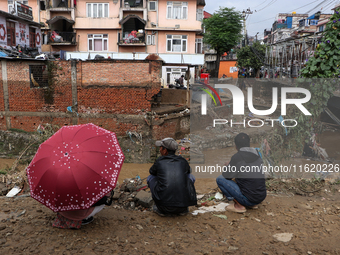 Locals of Imadol, Lalitpur, Nepal, look at their damaged home after heavy rain triggers a flood in local rivers in the area on September 29,...