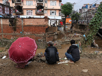 Locals of Imadol, Lalitpur, Nepal, look at their damaged home after heavy rain triggers a flood in local rivers in the area on September 29,...