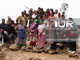 Spectators and relatives watch as the rescue teams conduct search operations at Jhyaple Khola in Dhading District, Nepal, on September 29, 2...