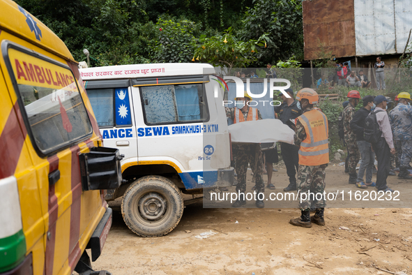 Rescue teams recover the bodies of bus passengers buried in a landslide in Jhyaple Khola, Dhading District, Nepal, on September 29, 2024, af...