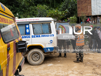 Rescue teams recover the bodies of bus passengers buried in a landslide in Jhyaple Khola, Dhading District, Nepal, on September 29, 2024, af...